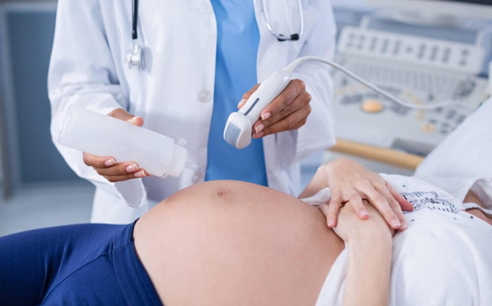 Pregnant woman receiving a ultrasound scan on the stomach in hospital